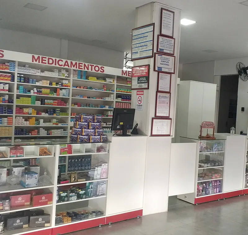 Balcão de atendimento de farmácia com vitrines e medicamentos organizados