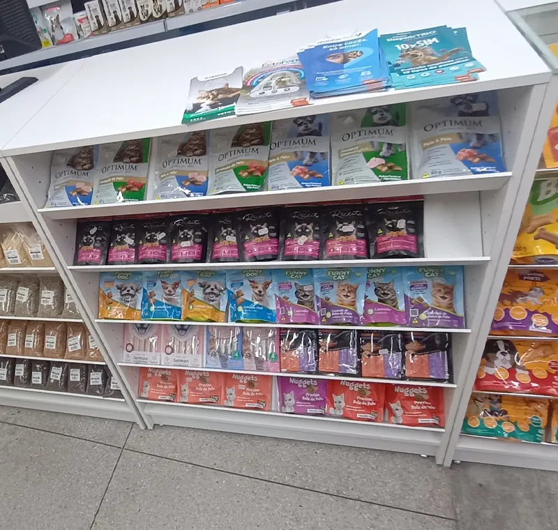 Gôndola branca com produtos para animais organizados por categoria