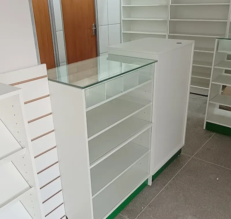 Balcão branco com vitrine de vidro e prateleiras para loja